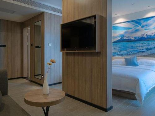 a bedroom with a large bed and a television at hailihotel in Dongguan