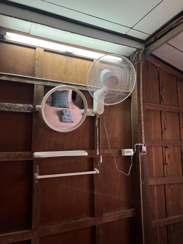 a room with a fan and a small window at Me Vadsana Homestay in Ban Mae Khachan (1)