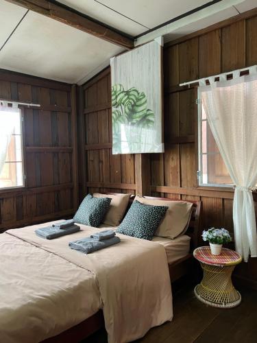 a bedroom with a large bed and a window at Me Vadsana Homestay in Ban Mae Khachan (1)