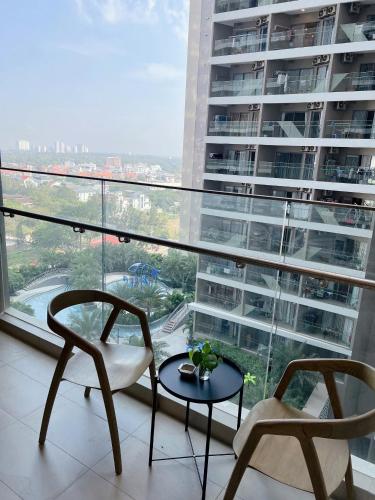 two chairs and a table in front of a large window at PƠ Homestay THESONG Vũng Tàu in Vung Tau