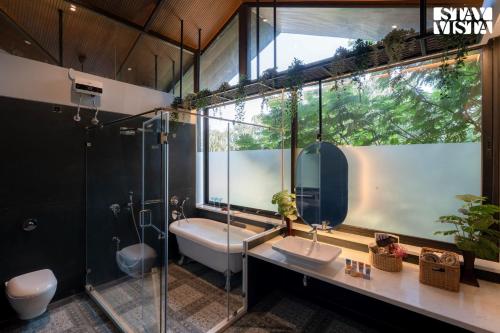 ein Badezimmer mit Waschbecken, Dusche und Toilette in der Unterkunft Nivaant Farms & Cottages - Nestled in lush greenery, offering a Swimming pool, Orchard, Jacuzzi & A spacious lawn with gazebo in Karjat