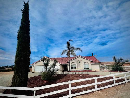una casa blanca con una valla y una palmera en Allura Encantado - Temecula Wine Retreat, en Temecula