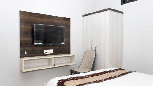 a bedroom with a bed and a tv on a wall at Darjeeling Homes The Grace in Darjeeling