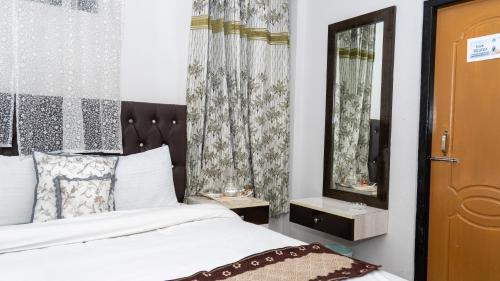 a bedroom with a bed and a mirror at Darjeeling Homes The Grace in Darjeeling