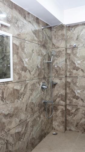 a bathroom with a shower with a stone wall at Darjeeling Homes The Grace in Darjeeling