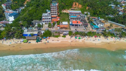an aerial view of a beach with a crowd of people at One World Mirissa in Mirissa