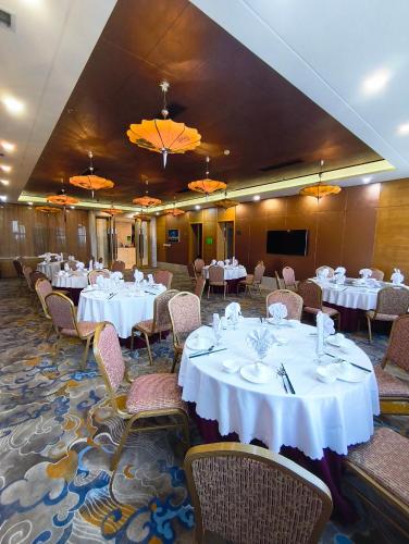 a banquet hall with white tables and chairs at Hotel Anda China Malabo in Malabo
