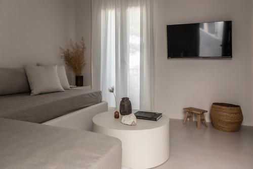 a white living room with a couch and a table at Om Living Milos in Pollonia