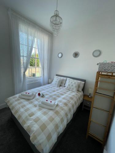 a bedroom with a bed with two towels on it at Buttercup Cottage in Dundrum