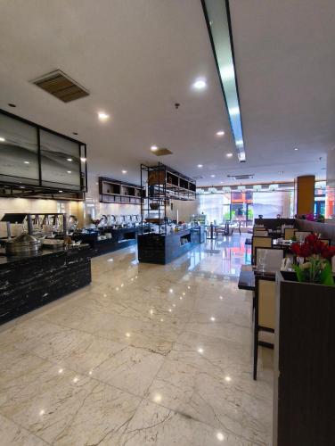 a restaurant with a large lobby with tables and counters at Hotel Anda China Malabo in Malabo