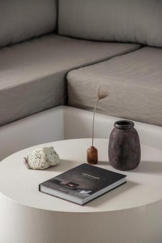 a table with a laptop and a vase on it at Om Living Milos in Pollonia