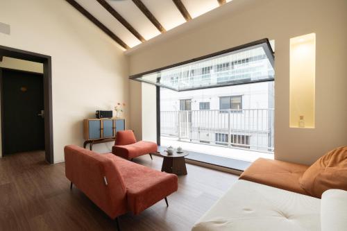 a living room with a couch and a large window at Boro Hanok Hostel in Myeongdong in Seoul