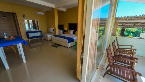 a room with a bedroom with a bed and chairs at One World Mirissa in Mirissa