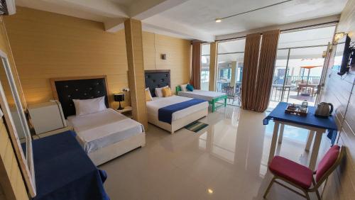 a hotel room with two beds and a couch at One World Mirissa in Mirissa