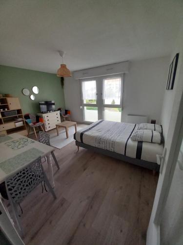 une chambre avec un lit et une table dedans dans l'établissement Appartement rénové et équipé, à Saint-Jacques-de-la-Lande