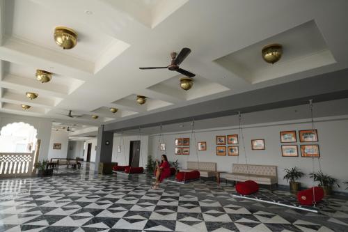 a woman standing in a lobby with a ceiling fan at ThePalaceByParkJewels in Jaipur