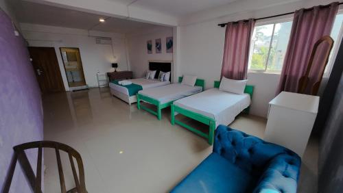 a living room with two beds and a couch at One World Mirissa in Mirissa