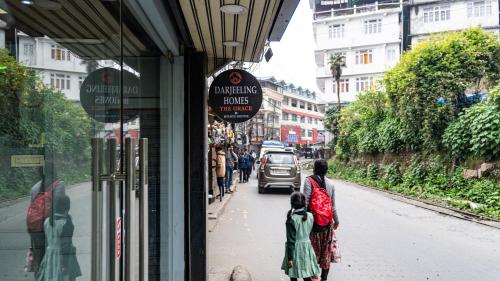 a woman and a child walking down a street at Darjeeling Homes The Grace in Darjeeling