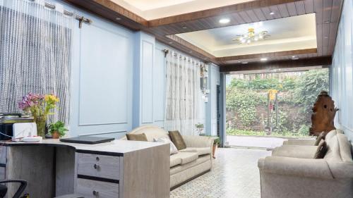 a living room with a couch and a table and chairs at Darjeeling Homes The Grace in Darjeeling