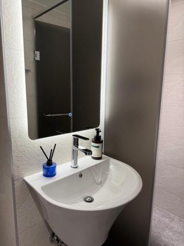 a white sink in a bathroom with a mirror at Boro Hanok Hostel in Myeongdong in Seoul