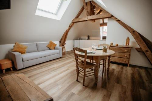 ein Wohnzimmer mit Tisch und Couch in der Unterkunft Les Anges 3 in Cambrai