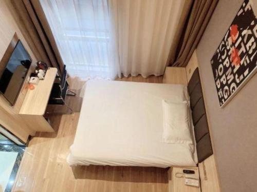 a small bedroom with a bed and a television at 7 Days Premium Shanghai Wild Animal Park Huinan in Shanghai