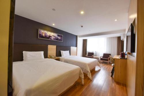 a hotel room with two beds and a television at 7 Days Premium Shanghai Wild Animal Park Huinan in Shanghai