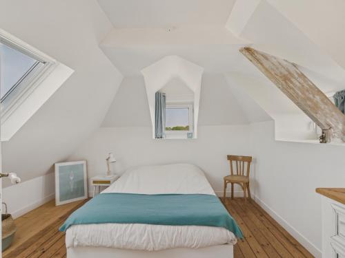a white bedroom with a bed and a window at Maison avec jardin pour 4 adultes et 2 enfants in Beg-Meil