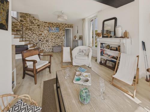 - un salon avec une table et des chaises ainsi qu'un mur en briques dans l'établissement Maison avec jardin pour 4 adultes et 2 enfants, à Fouesnant