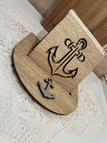 a wooden sign with an anchor on a table at Sailor's Rustic House in Virpazar