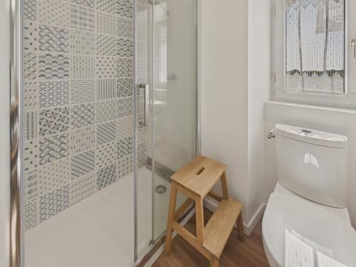 a bathroom with a shower with a stool next to a toilet at Maison avec jardin pour 4 adultes et 2 enfants in Beg-Meil