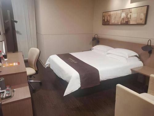 a hotel room with a bed and a desk at Jinjiang Inn Select Shanghai Fengxian Baolong Square North Yunhe Road in Shanghai