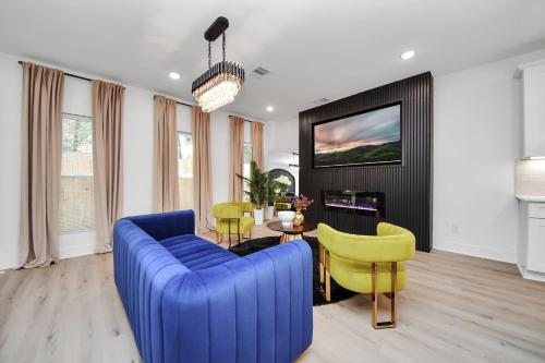 a living room with a blue couch and yellow chairs at The Prolific Stay - Where Luxury Meets Lifestyle in Houston