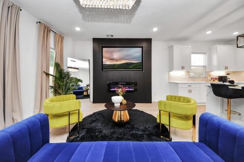 a living room with a blue couch and yellow chairs at The Prolific Stay - Where Luxury Meets Lifestyle in Houston