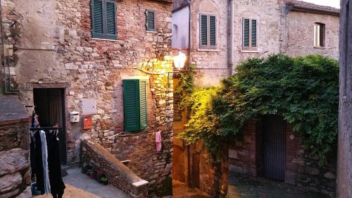 an old stone building with green shutters on it at Urlaub, wo die Toskana noch authentisch ist - Rustico aus 16Jh mit Infinity Pool in Pomarance