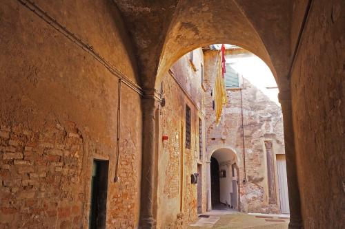 an alley with an archway in an old building at Urlaub, wo die Toskana noch authentisch ist - Rustico aus 16Jh mit Infinity Pool in Pomarance