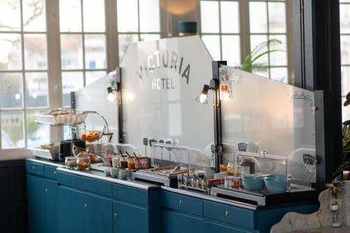 a buffet line with food on display in a restaurant at The Originals Boutique, Hôtel Victoria, Châtelaillon-Plage in Châtelaillon-Plage