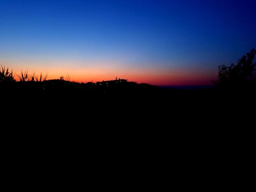 a sunset over a field with a silhouette at Urlaub, wo die Toskana noch authentisch ist - Rustico aus 16Jh mit Infinity Pool in Pomarance