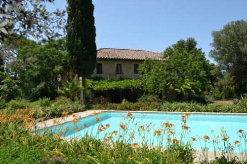an old house with a swimming pool in a garden at Urlaub, wo die Toskana noch authentisch ist - Rustico aus 16Jh mit Infinity Pool in Pomarance