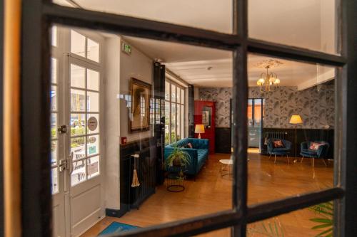 a view of a living room through a window at The Originals Boutique, Hôtel Victoria, Châtelaillon-Plage in Châtelaillon-Plage