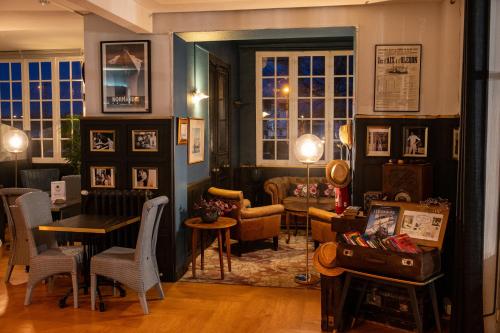a living room with a table and chairs in a room at The Originals Boutique, Hôtel Victoria, Châtelaillon-Plage in Châtelaillon-Plage