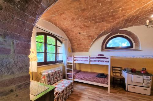 a bedroom with bunk beds in a brick wall at Urlaub, wo die Toskana noch authentisch ist - Rustico aus 16Jh mit Infinity Pool in Pomarance