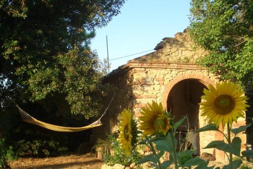 a stone building with a hammock in front of it at Urlaub, wo die Toskana noch authentisch ist - Rustico aus 16Jh mit Infinity Pool in Pomarance