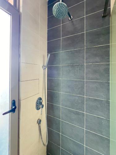 a shower with a shower head in a bathroom at Shaftsbury Cyberjaya in Cyberjaya