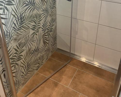 a shower stall with a black and white wallpaper at Ferienwohnung Altstadtliebe mit Dachterrasse in Riedenburg