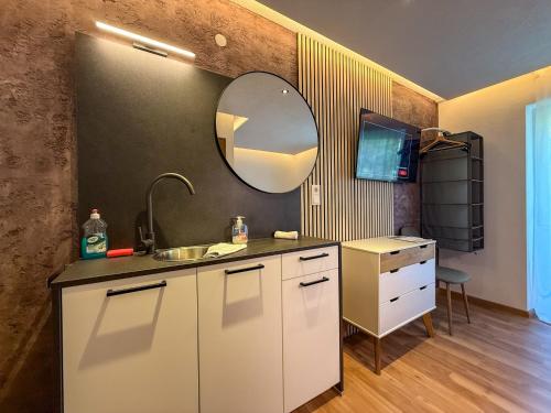 a kitchen with a sink and a mirror on the wall at Luna Studios Zillertal in Hippach