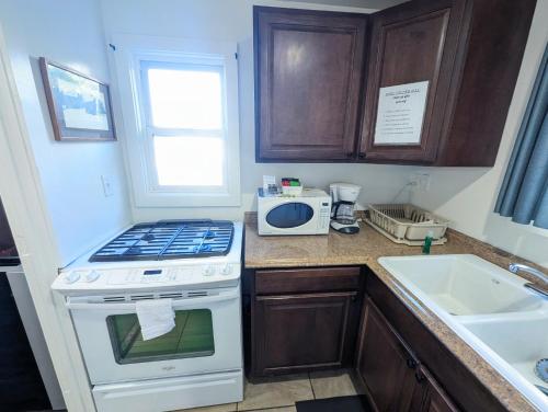 a kitchen with a stove top oven next to a sink at Fox n Bear Cottages Big Bear in Big Bear Lake