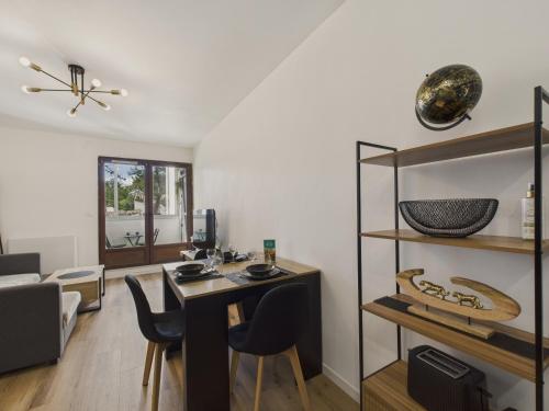 un salon avec une table et quelques chaises dans l'établissement 200m de la mer - Appartement pour 4 avec balcon, à Plage-des-Demoiselles