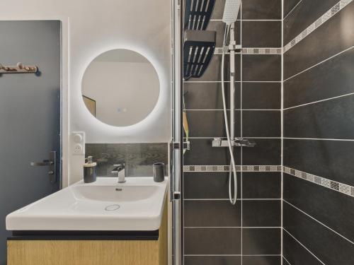 une salle de bain avec un lavabo et une douche dans l'établissement 200m de la mer - Appartement pour 4 avec balcon, à Plage-des-Demoiselles