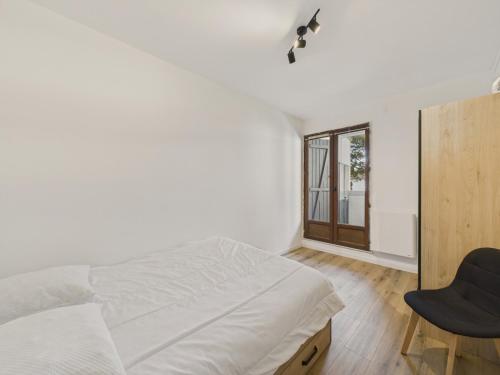 une chambre avec un lit, une chaise et une fenêtre dans l'établissement 200m de la mer - Appartement pour 4 avec balcon, à Plage-des-Demoiselles